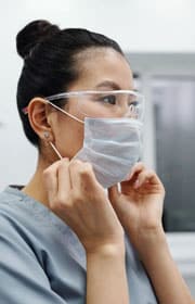 Dentist Putting On A Mask — Dentist In Gosford, NSW