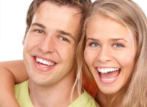 young couple with white teeth smiling
