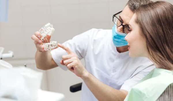 Prosthodontist speaking to patient with diagram